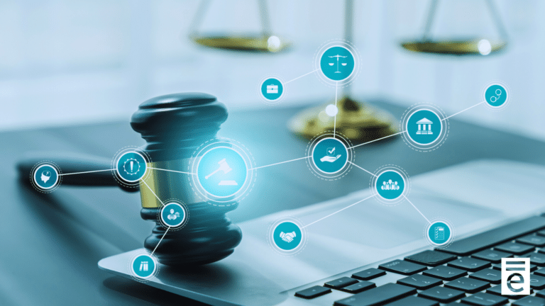 A photo of laptop with a gavel resting on top of it and the scales of justice in the background.